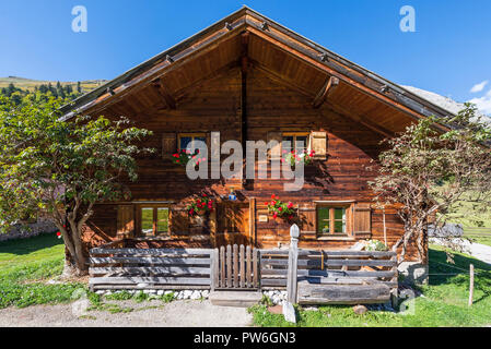 Holz- Almhütte mit Geranien in Blumenkästen auf der Eng-Alm auf der Großen Ahornboden im Sonnenlicht, Tirol, Österreich Stockfoto