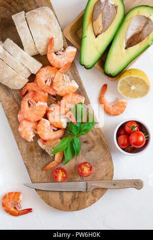 Die Zutaten für die Zubereitung von Bruschetta mit Garnelen und Avocado Stockfoto