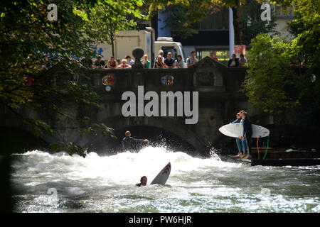 Es ist verboten, aber die Leute surfen im Englischen Garten Stockfoto