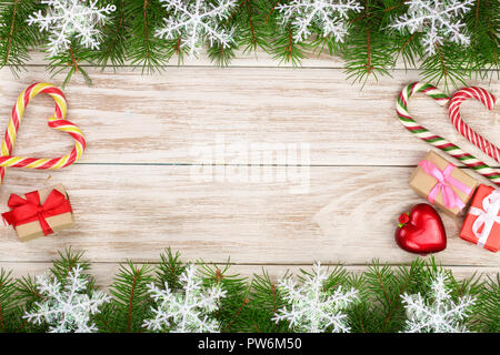 Weihnachten Rahmen aus Tannenzweigen mit Schneeflocken Zuckerstangen und Boxen auf einem hellen Hintergrund Stockfoto