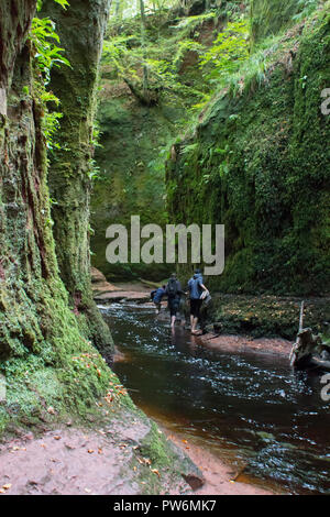 Kletterer climing durch den Teufel Kanzel Schlucht in die Trossachs von Schottland. Stockfoto