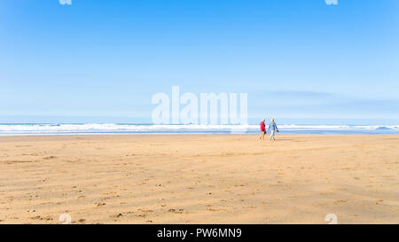 Ein paar Ein scrollen entlang einer Bude Cornwall Strand Stockfoto