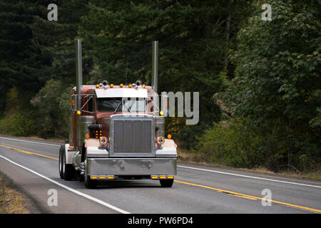 Classic American Idol Motorhaube perlmuttartig Brown Big Rig leistungsfähige Semi Truck Traktor mit Custom Chrome Zubehör und hohe Auspuffrohre fahren auf der f Stockfoto