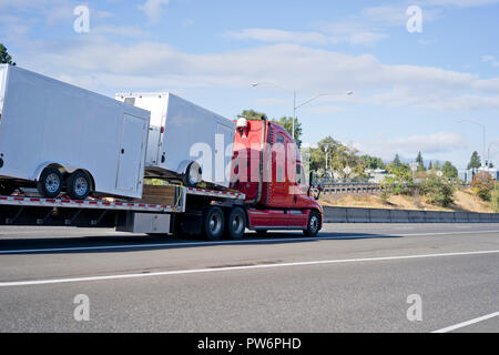 Leistungsstarke Motorhaube professionelle industrielle rot Big Rig Semi Truck Transport Cargo Anhänger Auflieger auf Schritt nach unten und bewegen auf dem breiten Markierung mu Stockfoto