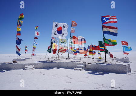 Eine Insel der Flags in der Mitte des Salar de Uyuni (bolivianischen Salt Flats), die eine Einheit von Nationen, Bolivien, Südamerika