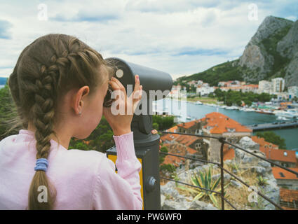 Kleines Mädchen mit Münze betrieben Panorama Teleskop. Stockfoto