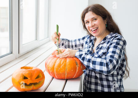 Urlaub, Halloween, Dekoration und Personen Konzept - Nahaufnahme der Frau mit Kürbisse zu Halloween vorbereiten Stockfoto