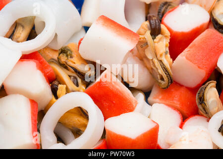 Eine geöffnete, Kunststoffbehälter mit gemischten Meeresfrüchten aus Garnelen, Tintenfisch, Muscheln und Meeresfrüchte beißt, gekauft von einem Supermarkt in Großbritannien. Dorse Stockfoto