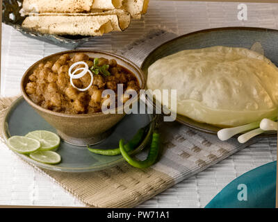 CHOLE BHATURA mit PAPAD SERVIERT MIT Limette, Zitrone, Zwiebeln, grüne Chilis/KICHERERBSEN mit gebratenen indisches Brot Stockfoto