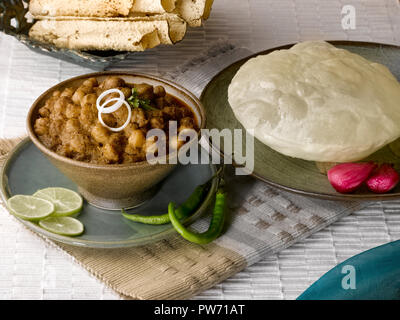 CHOLE BHATURA mit PAPAD SERVIERT MIT Limette, Zitrone, Zwiebeln, grüne Chilis/KICHERERBSEN mit gebratenen indisches Brot Stockfoto