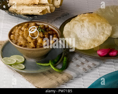 CHOLE BHATURA mit PAPAD SERVIERT MIT Limette, Zitrone, Zwiebeln, grüne Chilis/KICHERERBSEN mit gebratenen indisches Brot Stockfoto