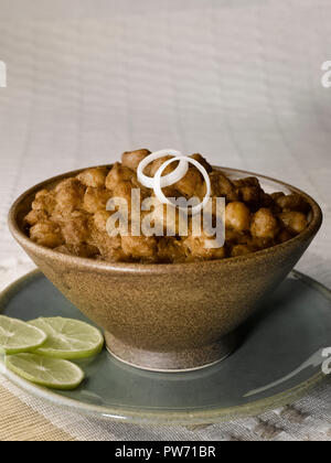 CHOLE BHATURA mit PAPAD SERVIERT MIT Limette, Zitrone, Zwiebeln, grüne Chilis/KICHERERBSEN mit gebratenen indisches Brot Stockfoto