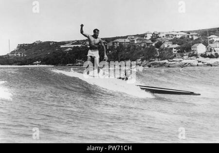 Mann und Frau auf einem longboard surfen Tandem 1945 an der Manly Beach, Sydney, Australien. (Foto von Ray Leighton) Stockfoto