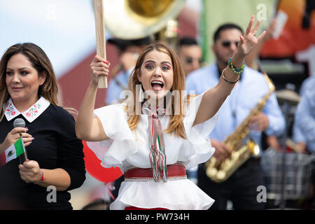 Chicago, Illinois, USA - 9. September 2018 der 26. Straße mexikanische Unabhängigkeit Parade, junge Frau winkte einen großen mexikanischen Flagge auf einem Schwimmer Stockfoto