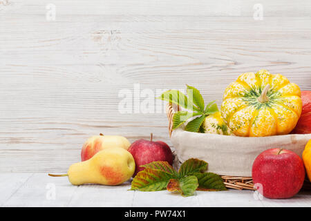 Herbst mit Kürbisse, Äpfel, Birnen und bunte Blätter vor der hölzernen Wand. Mit Platz für Ihren Text Stockfoto