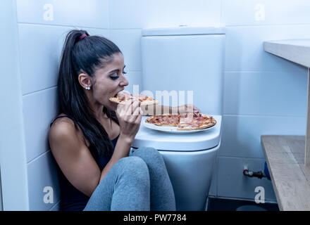 Attraktive Junge und traurig bulimic junge Frau fühlen sich schuldig und Kranken zu essen, während er auf dem Boden neben der Toilette bei Essstörungen Anorexie Stockfoto