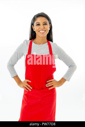 Portrait Of Happy stolz schönen lateinischen Frau trägt eine rote Schürze kochen lernen mit dem Daumen, die Geste in Kochkurse für kleine Unternehmen und hom Stockfoto