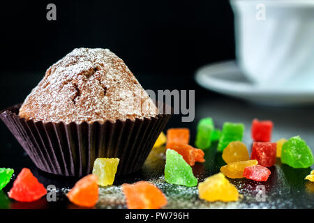 Frisch gebackene Muffins mit kandierten Früchten auf einem Schwarzen Tisch Stockfoto