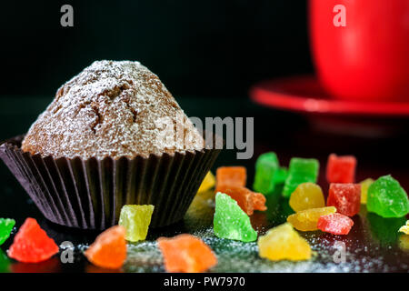 Frisch gebackene Muffins mit kandierten Früchten auf einem Schwarzen Tisch Stockfoto