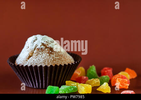 Frisch gebackene Muffins mit kandierten Früchten auf einem Schwarzen Tisch Stockfoto