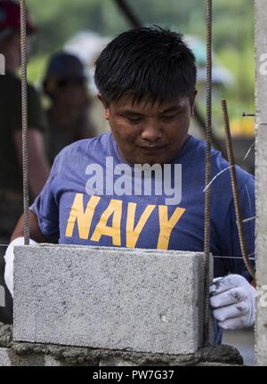 Philippinische Marine FN2 Elvis Julius legt einen Stein auf eine Wand der Küche bei Esperanza Grundschule zur Unterstützung der KAMANDAG in Casiguran, Aurora, Philippinen, Sept. 22, 2017. Bilaterale Übungen wie KAMANDAG erhöhen die Fähigkeit der Vereinigten Staaten und den Philippinen zu schnell reagieren und gemeinsam während der realen Welt terroristische oder humanitären Krisen, um die Mission zu erfüllen, die Unterstützung der lokalen Bevölkerung und menschliches Leid zu mindern. Stockfoto