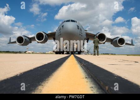 Us Air Force Senior Airman Austin Whisler, 21 Airlift Squadron C-17 Lademeister, Gespräche mit anderen Crew Mitglieder während eines Flugzeugs prüfen nach dem Laden der humanitären Hilfe auf eine C-17 Globemaster III Flugzeuge von Travis Air Force Base, Calif., Sept. 22, 2017 Joint Base San Antonio-Lackland Kelly Feld, Texas. Die humanitäre Hilfe wurde nach St. Croix, US Virgin Islands geliefert, nachdem die Insel Schäden vom Hurrikan Maria erlitten hatte. Stockfoto