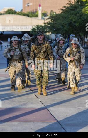 Us Marine Corps Kapitän Andrew Hotsko, Offizier der Offizier Auswahl office College Station, führt Officer Kandidaten mit Offiziervorwähler Office College Station Texas, auf einer 6 km langen Wanderung während Fire team Wettkämpfe auf der Texas A&M University Campus, Sept. 22, 2017. Feld Übungen besser vorbereitet Kandidaten für Officer Kandidaten School (OCS), und die Abnutzung am Kurs zu reduzieren. Stockfoto