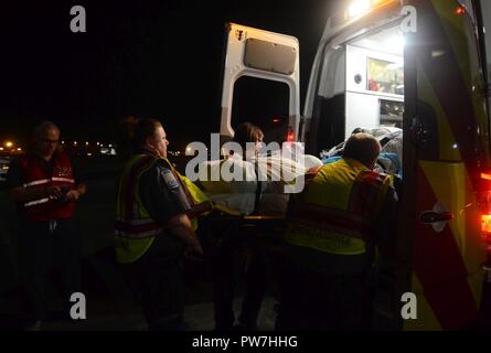 Medizinische Personal laden Sie einen Patienten in einem Rettungswagen auf Dobbins Air Reserve Base, Ga Sept. 23, 2017. Umsiedler wurden von St. Croix, US Virgin Islands West für den Transport nach Atlanta, medizinische Einrichtungen in der Nachmahd des Hurrikans Maria geflogen. Stockfoto