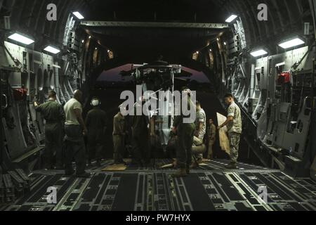 ROYAL AUSTRALIAN AIR FORCE BASE DARWIN, Australien - US-Marines mit Marine Light Attack Helicopter Squadron 367, Marine Drehkraft Darwin Ein UH-1Y Venom Last auf einem C-17 Globemaster III, Sept. 25, 2017. HMLA-367 erfolgreich abgeschlossen Der Einsatz für die Unterstützung von MRF-D. Die Marines mit einem strategischen lift Methode Transportflugzeug weltweit. Stockfoto