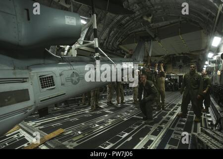 ROYAL AUSTRALIAN AIR FORCE BASE DARWIN, Australien - US-Marines mit Marine Light Attack Helicopter Squadron 367, Marine Drehkraft Darwin Ein UH-1Y Venom Last auf einem C-17 Globemaster III, Sept. 25, 2017. HMLA-367 erfolgreich abgeschlossen Der Einsatz für die Unterstützung von MRF-D. Die Marines mit einem strategischen lift Methode Transportflugzeug weltweit. Stockfoto