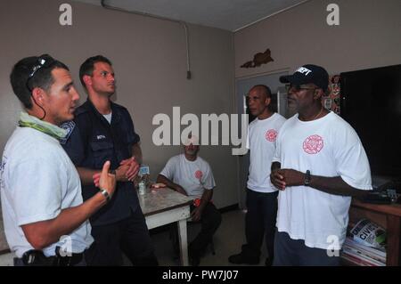 Mitglieder der Fairfax County Urban Suche und Rettung Task Force, Federal Emergency Management Agency aus Virginia, Dan Gajewski und Louis Botha sprechen mit dem Chef der Emile Henderson Feuerwache in Frederiksted, Larry Johnson über die Mitglieder der Gemeinschaft im Regenwald Region - im Westen von St. Croix, Sept. 22. Stockfoto