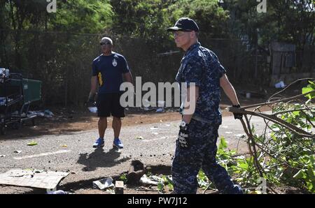 AIEA, Hawaii (Sep. 22, 2017) Kapitän Jeff Bernard, Joint Base Commander, rechts, hilft freiwillige Helfer aus dem Chaos der Joint Base Pearl Harbor-Hickam (JBPHH) Chief's und First Class Petty Officer Association klar invasive Mangrovenbäume aus der Pearl Harbor Radweg entlang der historischen Waterfront von Pearl Harbor in Radevormwald, für die Phase zwei der Restaurierung der Radweg, September 22. JBPHH und die Stadt und die Grafschaft von Honolulu haben zusammengearbeitet, um für 12 Jahre bis der Radweg und Host freiwilligen Bemühungen mindestens zweimal im Jahr zu reinigen. Stockfoto