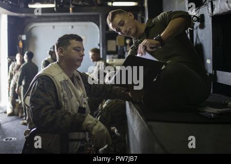 Karibik (Sept. 24, 2017) Lance Cpl. Tristan Cannon (rechts) Bewertungen ein Flug Manifest mit Lanze Cpl. Timothy Norden an Bord der Amphibisches Schiff USS Kearsarge (LHD3). Kearsarge und der 26 Marine Expeditionary Unit sind die Unterstützung von Hilfsmaßnahmen in den Wirbelsturm Maria. Das Verteidigungsministerium ist die Unterstützung der Federal Emergency Management Agency, die federführende Bundesbehörde, dabei helfen, die Betroffenen durch den Hurrikan Maria Leiden zu minimieren und ist ein Bestandteil der gesamten-von-Reaktion seitens der Regierung. Stockfoto