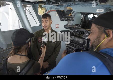 Karibik (Sept. 24, 2017) Lance Cpl. Christian Melone Rodriguez ist durch die Reporter von Univision auf der Brücke interviewt an Bord der Amphibisches Schiff USS Kearsarge (LHD3). Kearsarge unterstützt mit Hilfsmaßnahmen in den Wirbelsturm Maria. Das Verteidigungsministerium ist die Unterstützung der Federal Emergency Management Agency, die federführende Bundesamt, in denen helfen, die vom Hurrikan Irma Betroffene leiden zu minimieren und ist ein Bestandteil der gesamten-von-Reaktion seitens der Regierung. Stockfoto