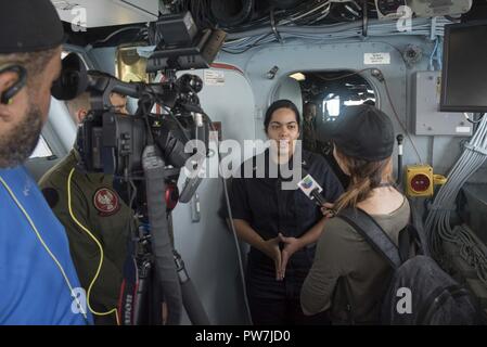 Karibik (Sept. 24, 2017) Intelligence Specialist 3. Klasse Dalismar Solermartell ist durch die Reporter von Univision auf der Brücke interviewt an Bord der Amphibisches Schiff USS Kearsarge (LHD3). Kearsarge unterstützt mit Hilfsmaßnahmen in den Wirbelsturm Maria. Das Verteidigungsministerium ist die Unterstützung der Federal Emergency Management Agency, die federführende Bundesamt, in denen helfen, die vom Hurrikan Irma Betroffene leiden zu minimieren und ist ein Bestandteil der gesamten-von-Reaktion seitens der Regierung. Stockfoto