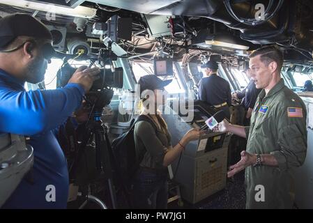 Karibik (Sept. 24, 2017) der hinteren Adm. Jeff Hughes, Kommandeur der Expeditionary Strike Group (ESG) 2, von den Reportern von Univision auf der Brücke interviewt wird an Bord der Amphibisches Schiff USS Kearsarge (LHD3). Kearsarge unterstützt mit Hilfsmaßnahmen in den Wirbelsturm Maria. Das Verteidigungsministerium ist die Unterstützung der Federal Emergency Management Agency, die federführende Bundesamt, in denen helfen, die vom Hurrikan Irma Betroffene leiden zu minimieren und ist ein Bestandteil der gesamten-von-Reaktion seitens der Regierung. Stockfoto