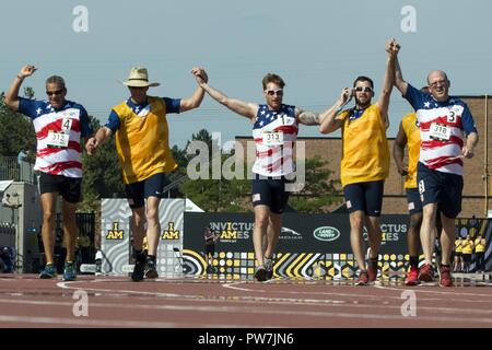 Pensionierte US Special Operations Command Maj. Ivan Castro, Links, pensionierter Navy Leutnant Bradley Snyder, Mitte, und pensionierte Army Staff Sgt. Sean Johnson, rechts, beenden die Männer 1500 Meter laufen gemeinsam während des 2017 Invictus Spiele bei York-Lions Stadion in Toronto am 25. September 2017. Die Invictus Games, von Prinz Harry im Jahr 2014 gegründet, vereint die Verwundeten und verletzten Veteranen aus 17 Nationen für 12 adaptive Sportveranstaltungen, einschließlich Leichtathletik, Rollstuhl basketball Rollstuhl Rugby, Schwimmen, Volleyball, und Neu in der 2017 Spiele, Golf. Stockfoto