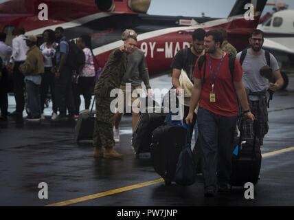 Us Marine Gunnery Sgt. Philip C. Sackett, Mitte, mit Joint Task Force - Leeward Inseln, leitet US-Bürger zur Evakuierung Control Center an Douglas-Charles Flughafen in Dominica, Sept. 24, 2017. Das Control Center wurde eingerichtet, die in den freiwilligen Evakuierung von US-Bürgern auf Dominica gestrandet nach Hurrikan Maria zu unterstützen. Auf Anfrage der Partnerländer und sowohl das State Department und der US-Agentur für Internationale Entwicklung, JTF-LI hat Flugzeuge und Service Mitglieder zu den Bereichen in der östlichen Karibik bereitgestellt, die von den Hurrikanen Irma und Maria. Die Task Force ist ein U Stockfoto