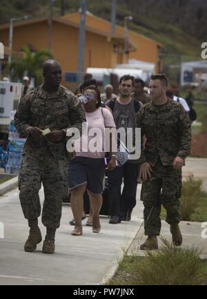 Us-Marines Staff Sgt. Christopher K. Bamfo und Gunnery Sgt. Philip C. Sakett, mit Joint Task Force - Leeward Inseln, Escort US-Bürger von der Evakuierung Control Center zu den Flug Linie an Douglas-Charles Flughafen in Dominica, Sept. 24, 2017. Das Control Center wurde eingerichtet, die in den freiwilligen Evakuierung von US-Bürgern auf Dominica gestrandet nach Hurrikan Maria zu unterstützen. Auf Anfrage der Partnerländer und sowohl das State Department und der US-Agentur für Internationale Entwicklung, JTF-LI hat Flugzeuge und Service Mitglieder zu den Bereichen in der östlichen Karibik bereitgestellt von Hu Stockfoto