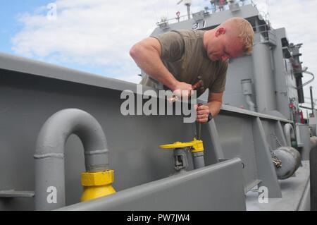 Us-Armee SPC. Ryan Jones, ein watercraft Bediener zugeordnet zu den 824Th Transportation Company (schwere Boot), bereitet eine Kraftstoffversorgungsleitung an Bord der US-Armee Landing Craft Utility 2031 New Orleans Sept. 24, 2017 in Tampa, Fla. Die Besatzung des Schiffes zum Handeln aufgerufen wurde ein Notfall der Bereitstellungsbereitschaft Übung zur Durchführung des Auftrags der Armee Finden humanitäre Hilfe nach Puerto Rico und anderen betroffenen Bereichen durch den Hurrikan Maria zu unterstützen. Die seemänner reagierte rasch auf den Ruf ihres Schiffes für Blindbewerbungen vorbereiten. Stockfoto