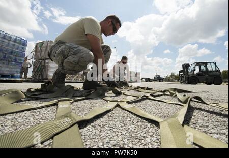 Us Air Force Tech. Sgt. Antonio Montano, 502Nd Logistik Bereitschaft Squadron noncommissioned Officer Leiter des persönlichen Eigentums und Senior Airman Sarah Nededog, 502 LRS Traffic Management Facharbeiter, ein Cargo Net, die verwendet werden, um zu helfen, palettieren Lebensmittel und Wasser in die Luft geflogen Hilfsmaßnahmen in Puerto Rico und Saint Croix im Hurrikan Maria, an Joint Base San Antonio-Kelly Feld, Texas, Sept. 23, 2017 unterstützt werden. Insgesamt tritt der Active Duty, Air National Guard, und Air Force Reserve Command Flieger arbeiten Seite an Seite mit Bund, Land, Kommune und Internat Stockfoto