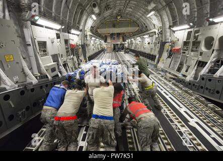 Us Air Force Mitglieder ab dem 3. Airlift Squadron, 502Nd Logistik Bereitschaft Squadron und 433Rd LRS Laden einer C-17 Globemaster III des 3. Als von Dover Air Force Base, Del zugeordnet, mit Paletten mit Nahrung und Wasser per Luftbrücke Hilfsmaßnahmen in Puerto Rico und Saint Croix nach dem Hurrikan Maria, an Joint Base San Antonio-Kelly Feld, Texas, Sept. 23, 2017 zu unterstützen. Insgesamt tritt der Active Duty, Air National Guard und der Air Force Reserve Command Flieger arbeiten Seite an Seite mit föderalen, staatlichen, lokalen und internationalen Mission Partner Leiden zu lindern und in der nat-Unterstützung Stockfoto