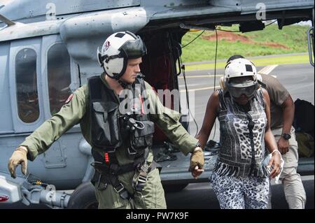 DOMINICA (Sept. 25, 2017) Naval Aircrewman (Hubschrauber) 2. Klasse Nikolaus Glas, zu Hubschrauber Meer Combat Squadron (HSC) 22, angeschlossen an den amphibischen Angriff Schiff USS Wasp (LL 1), Escorts ein Bewohner für die Evakuierung nach dem Landfall Hurrikan Maria zugeordnet. Dominica Bewohner werden von ihrer Insel zu den nahe gelegenen Inseln Martinique und Guadalupe evakuiert. Das Verteidigungsministerium ist die Unterstützung der US-Behörde für Internationale Entwicklung (USAID), die Leitung der Föderalen Agentur, dabei helfen, die Betroffenen durch den Hurrikan Maria Leiden zu minimieren und ist eine Komponente der Th Stockfoto