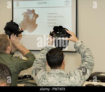 Us Air Force Piloten prüfen ihre Gasmasken während eines chemischen, biologischen, radiologischen und nuklearen Verteidigung survival skills Training Kurs auf Travis Air Force Base, Calif., Sept. 21, 2017. CBRN-Abwehr sind Schutzmaßnahmen in Fällen, in denen chemische, biologische, radiologische oder nukleare Kriegsführung (einschließlich Terrorismus) Gefahren vorhanden sein können. CBRN CBRN-Verteidigung besteht aus passiven Schutz, Verschmutzung Vermeidung und Abwehr von ABC-Waffen und Risikominderung. Stockfoto