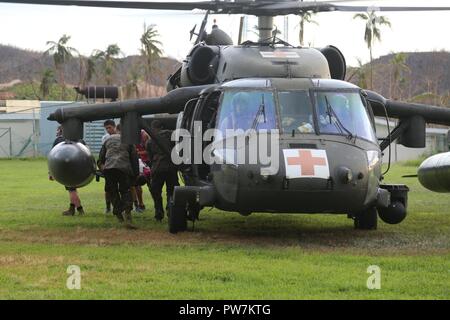 Us-Marines mit Joint Task Force - Leeward Islands und Ross Medizinische Universität Personal tragen eine verletzte Person aus einem US-Army UH-60 Black Hawk in Dominica, Sept. 24, 2017. Us-Mitglieder mit JTF-LI eine Evakuierung Control Center am Flughafen Douglas-Charles in der freiwilligen Evakuierung von US-Bürgern auf Dominica gestrandet nach Hurrikan Maria zu unterstützen. Auf Anfrage der Partnerländer und sowohl das State Department und der US-Agentur für Internationale Entwicklung, JTF-LI hat Flugzeuge und Service Mitglieder zu den Bereichen in der östlichen Karibik bereitgestellt durch Hurrikane I Stockfoto