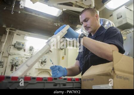 5. Flotte BEREICH VON OPERATIONEN (Sept. 25, 2017) Flieger Morgan Collins, ein Eingeborener von Durban, Südafrika, zugeordneten Abteilung in die Luft an Bord der Amphibisches Schiff USS America (LHA 6), bereitet die Grippeschutzimpfungen für die Administration in das Schiff nach der Schlacht dressing Station. Amerika ist das Flaggschiff der Amerika amphibische Gruppe und bereit, mit der begonnen 15 Marine Expeditionary Unit, ist in die USA 5 Flotte Bereich für Maßnahmen zur Erhöhung der Sicherheit im Seeverkehr im Einsatz Verbündeten und Partnern zu beruhigen und der Freiheit der Schiffahrt und des freien Handels in der Region erhalten. Stockfoto