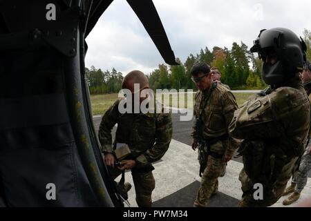 Us-Armee Sgt. Keith Jesmain, rechts, bis 12 Combat Aviation Brigade zugeordnet, beobachtet der tschechischen Soldaten ein UH-60 Black Hawk während die besten europäischen Sniper Squad Wettbewerb geben Sie an der 7th Army Training Befehl Grafenwöhr Training Area, Germany, Sept. 26, 2017. Die Europäische beste Sniper Squad-Wettbewerb ist eine US-Armee Europa Konkurrenz, anspruchsvolle Militärs aus ganz Europa zu konkurrieren und die Zusammenarbeit mit Verbündeten und Partner Nationen verbessern. Stockfoto