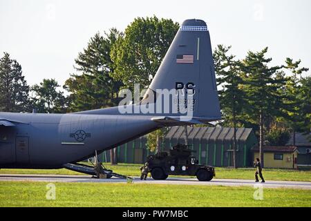 Ein High Mobility Multipurpose Radfahrzeug vom 1.BATAILLON, 503Rd Infanterie Regiment, 173Rd Airborne Brigade, entlastet von der US Air Force 86th Air Wing C-130 Hercules aus der 86th Air Wing, während der übung September Hitze 2017 in Rivolto italienische Air Force Base, Udine, Italien, Sept. 26, 2017. Die 173Rd Airborne Brigade ist der US-Armee Contingency Response Force in Europa, die in der Projektion bereit Kräfte überall in den USA in Europa, Afrika oder Verantwortungsbereich Zentrale Befehle". Stockfoto