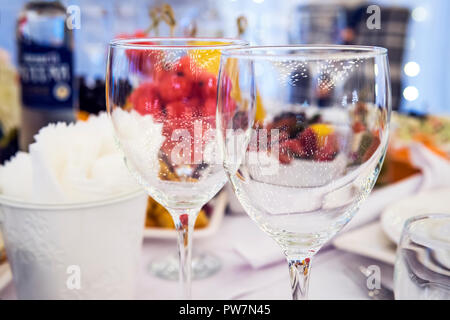 Luxus elegant gedeckten Tisch zum Abendessen in einem Restaurant. Stemwares auf eine festliche Hochzeit wunderschön dekorierten Tisch. Poliert Weingläser auf ein Restaurant Stockfoto