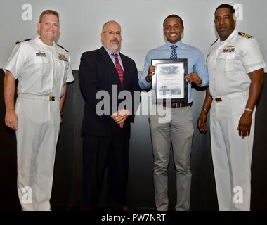 DAHLGREN, VA - James Finnie erhält seine Urkunde von Naval Surface Warfare Center Dahlgren Division (NSWCDD) Technischer Direktor John Fiore, NSWCDD befehlshabenden Offizier, Kapitän Godfrey 'Gus' Weekes, rechts, und die Bekämpfung der Richtung Activity Dam Hals Kommandierender Offizier Cmdr. Andrew Hoffman am 2017 NSWCDD Akademische Preisverleihung. Finnie war für den Abschluss seines Meisters in der cybersicherheit Engineering von Morgan State University anerkannt und gelobt für sein Engagement für die persönliche und berufliche Entwicklung. Stockfoto